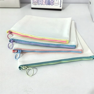 Detail of four canvas pouches with colorful zippers and large circular pull rings