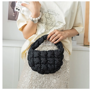 Gros plan du sac nuage noir matelassé montrant la texture plissée et la poignée rembourrée