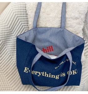 Große blaue Denim-Canvas-Tragetasche mit gelber handgeschriebener Typografie im Detail