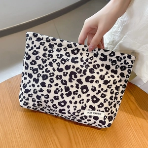 Detail of leopard print corduroy makeup bag with woven May Rabbit label and soft texture