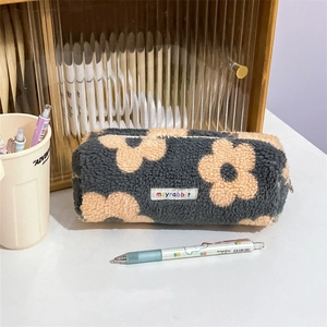 Close-up of floral plush pencil case with zipper and embroidered mayrabbit brand tag