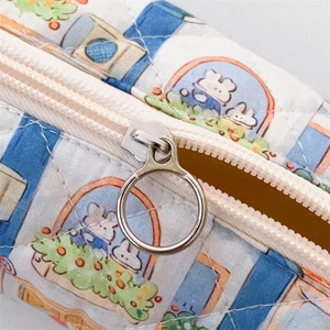 Close-up of diamond quilted floral bag showing silver metal zipper and soft fabric texture