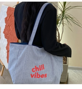 Detail einer blau gestreiften Canvas-Einkaufstasche mit rotem Chill Vibes-Stick