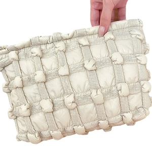 Quilted cloud puffer pouch in creamy white canvas with bubble texture and gold zipper