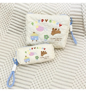 Detail of embroidered Puppy Baby pattern on cream quilted cosmetic bag set