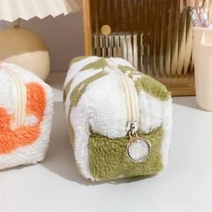 Close-up of floral plush storage bag with round metal zipper on a warm desk