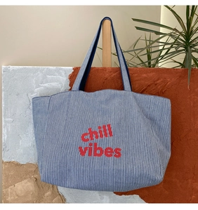Detail der blau-weiß gestreiften Canvas-Einkaufstasche mit rotem Chill Vibes-Aufdruck und Gurt