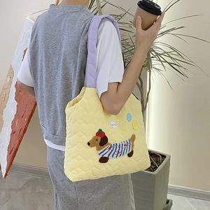 Detail of heart quilting and cute puppy embroidery on yellow contrast shoulder bag
