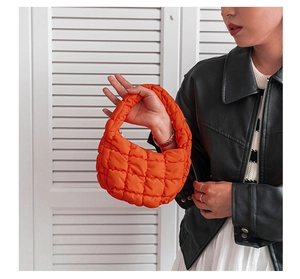 Détail du sac bulle matelassé orange vif en nylon avec texture à carreaux rembourrée