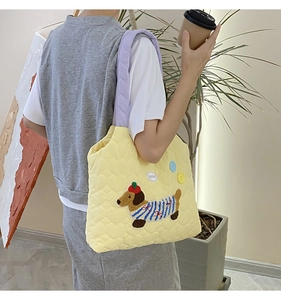 Detail of quilted tote bag with cute dog embroidery and lavender shoulder straps
