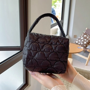 Close-up of quilted puffy cloud texture on black nylon portable makeup handbag