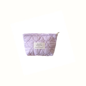 Lavender quilted makeup bag with heart pattern and gold zipper on white background