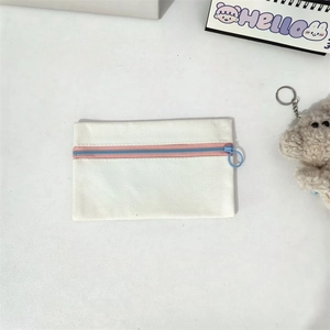 Detail of canvas pouch with pink contrast zipper and light blue metal puller