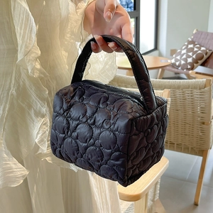 Detail of black quilted puffer cosmetic bag showing cloud texture and padded handle