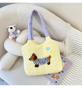 Detail of yellow quilted tote bag with cute dog patch and large colorful buttons