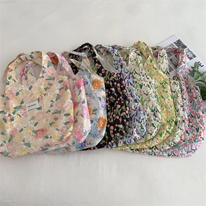 Vue à plat de plusieurs sacs en toile à imprimé floral avec motifs de tulipes et étiquette