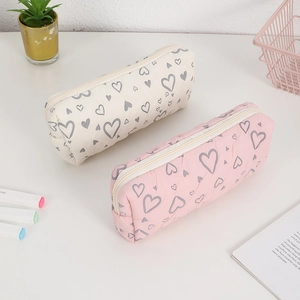 Detail of quilted floral pencil cases in pink and beige with heart patterns and zippers