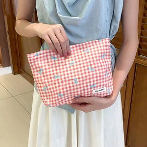 Dettaglio della trousse a quadretti rossi con fiocchi blu ed etichetta May Rabbit