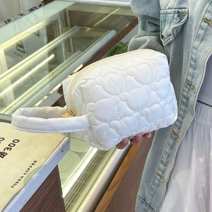 Détail de la trousse de maquillage blanche matelassée avec motifs ours et zip doré