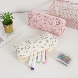 Close-up of quilted floral heart pencil cases with soft fabric texture and zipper detail