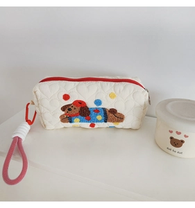 Detail of heart quilted cosmetic bag with cute dog towel embroidery and red zipper