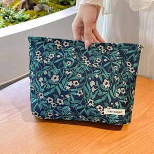 Detail of blue jacquard floral toiletry bag with leaf pattern and May Rabbit label