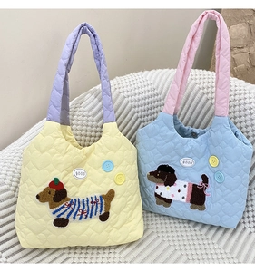 Detail of heart-quilted canvas tote bags with cute dachshund dog embroidery and pastel colors