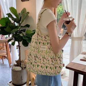 Vue détaillée du motif floral de tulipes et de la texture du tissu d'un sac en toile