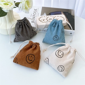 Corduroy drawstring storage bags with smiley faces in grey, blue, brown, and beige colors