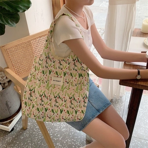 Sac fourre-tout à fleurs tulipes porté par un mannequin pour un look décontracté