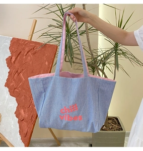 Makroaufnahme der gestreiften Segeltuchtasche mit rosa Aufdruck und Kontrastfutter