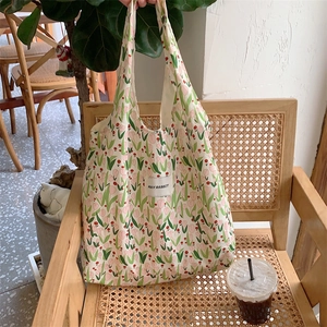 Détail du sac cabas en toile à fleurs avec tulipes roses et étiquette de marque HAY RABBIT
