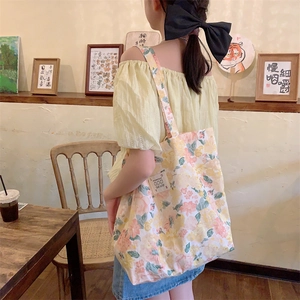 Détail du cabas en toile florale avec motifs de fleurs roses et étiquette décorative