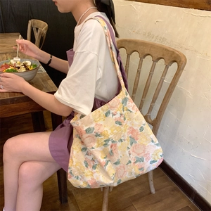 Floral canvas tote bag with yellow flowers shown in a casual lifestyle setting
