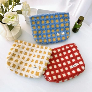 Three colorful waffle texture cosmetic bags with checkered patterns in a home setting