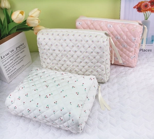 Detailed view of quilted cotton makeup bags in pink animal, cherry, and floral patterns