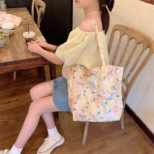 Détail du sac cabas en toile florale avec des motifs roses et oranges sur tissu de qualité