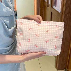 Dettaglio della borsa cosmetica a quadretti rosa con fiocchi ed etichetta MAY RABBIT