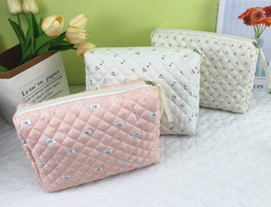 Detailed view of quilted cotton makeup bags with rabbit, cherry and floral prints