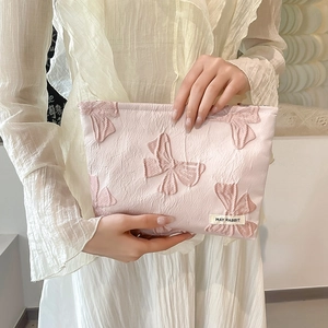 Detail of pink floral bow cosmetic bag with metal zipper and soft fabric texture