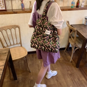 Vue détaillée du sac cabas en toile à fleurs avec grande capacité et étiquette logo