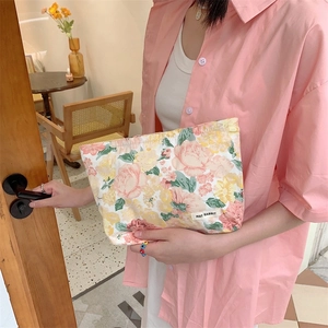 Floral makeup bag detail showing May Rabbit label and pink rose pattern on canvas