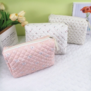 Detailed view of three quilted makeup bags with rabbit, cherry, and floral patterns