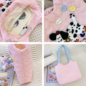 Detail view of pink quilted tote bag with cute dog embroidery and blue handles