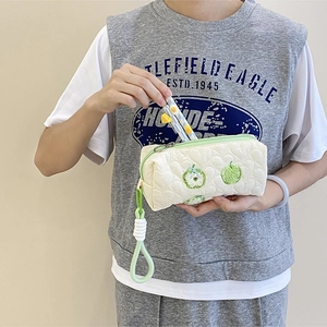 Detail of quilted pencil case with green apple embroidery and a wide wrist strap handle