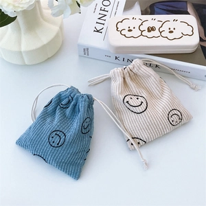 Detail of corduroy drawstring pouches with smiley embroidery and a cute dog print storage box
