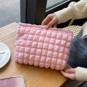 Detailed view of pink bubble texture on large capacity quilted puffy makeup bag