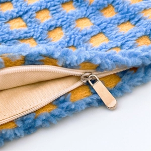 Detail of soft blue and yellow checkered waffle makeup bag with a sturdy metal zipper