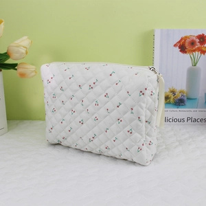 Detail of cherry print quilted makeup bag with soft texture and sturdy metal zipper