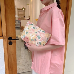 Close-up of floral canvas toiletry bag featuring May Rabbit tag and pink flower patterns
